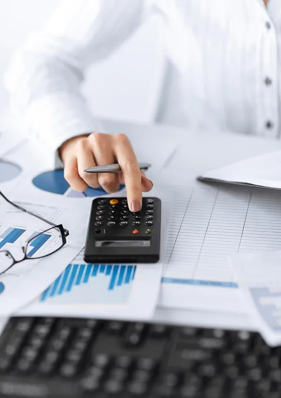 Calculator, eyeglasses and financial charts